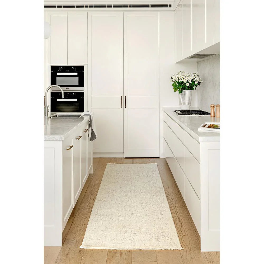 Emma Blomfield Rogue Linen Runner Rug featuring crackle-textured pattern in ivory and cream on warm beige oak floor, woven linen