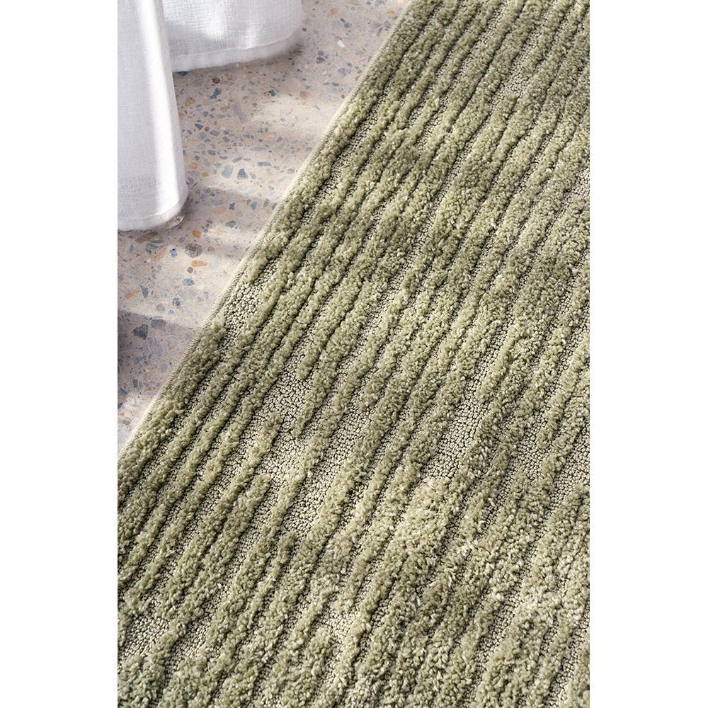 Marigold Suri Green Rug featuring textured striped pattern in olive green, sage and cream on light terrazzo floor, hand-tufted wool