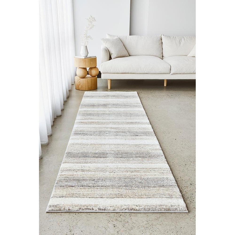 Striped area rug in a living room setting with a white sofa and side table.