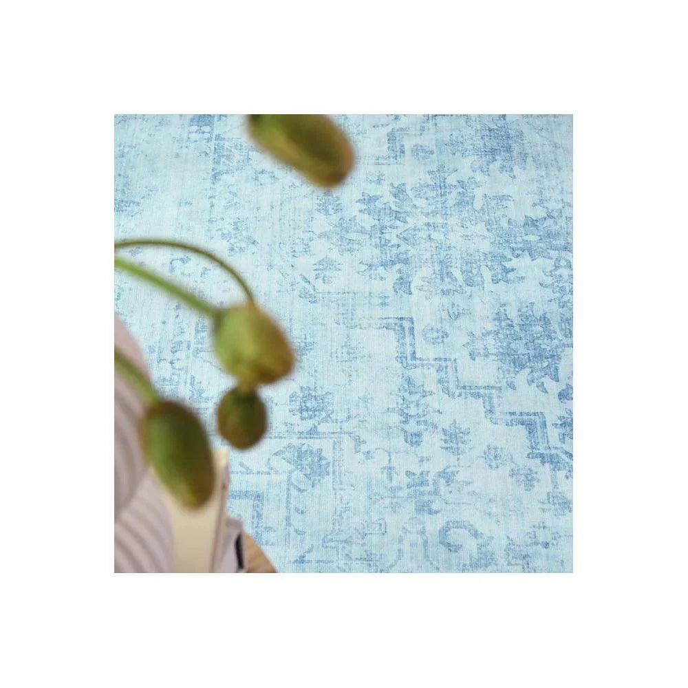 Gemstone Aquamarine Rug featuring distressed vintage floral pattern in aquamarine, sky blue, navy on pale blue background, hand-tufted wool