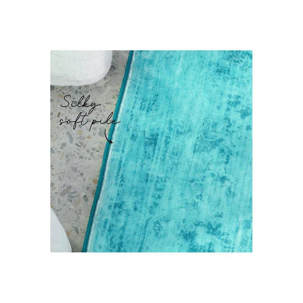Gemstone Topaz Rug featuring distressed solid pattern in turquoise, teal and aqua on light concrete background, hand-tufted wool