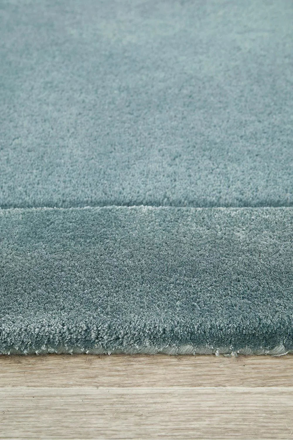 Hugo Blue Runner Rug featuring solid texture in teal blue, dusty blue and steel blue on light oak floor, machine-made polypropylene