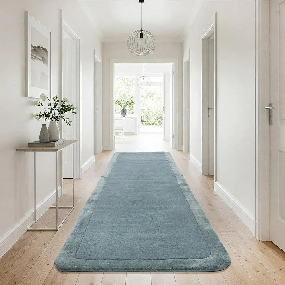 Hugo Blue Runner Rug featuring solid minimalist design in dusty blue and steel blue on cream hallway floor, machine-made polyester