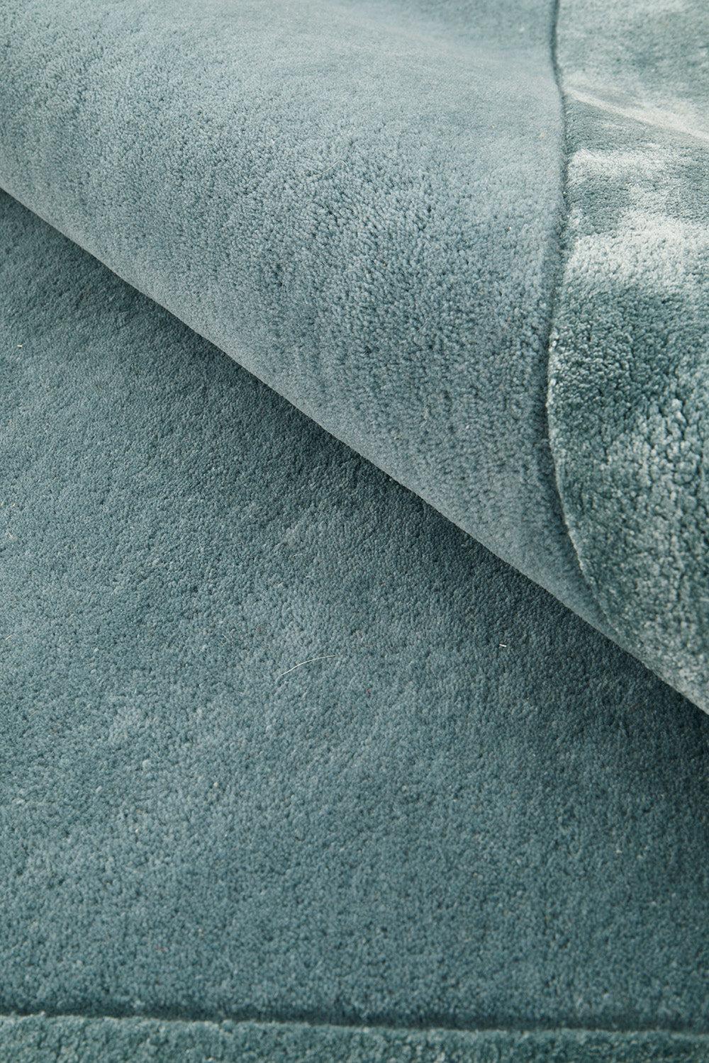 Hugo Blue Rug featuring solid textured pattern in blue-teal, dusty blue, steel blue on blue background, hand-tufted wool