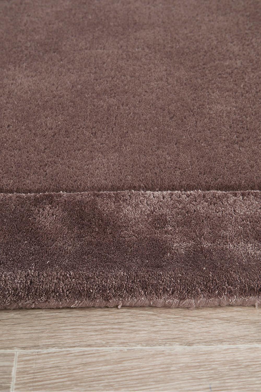 Hugo Grape Runner Rug featuring solid colour shaggy texture in grape purple on warm brown wood floor, hand-tufted wool