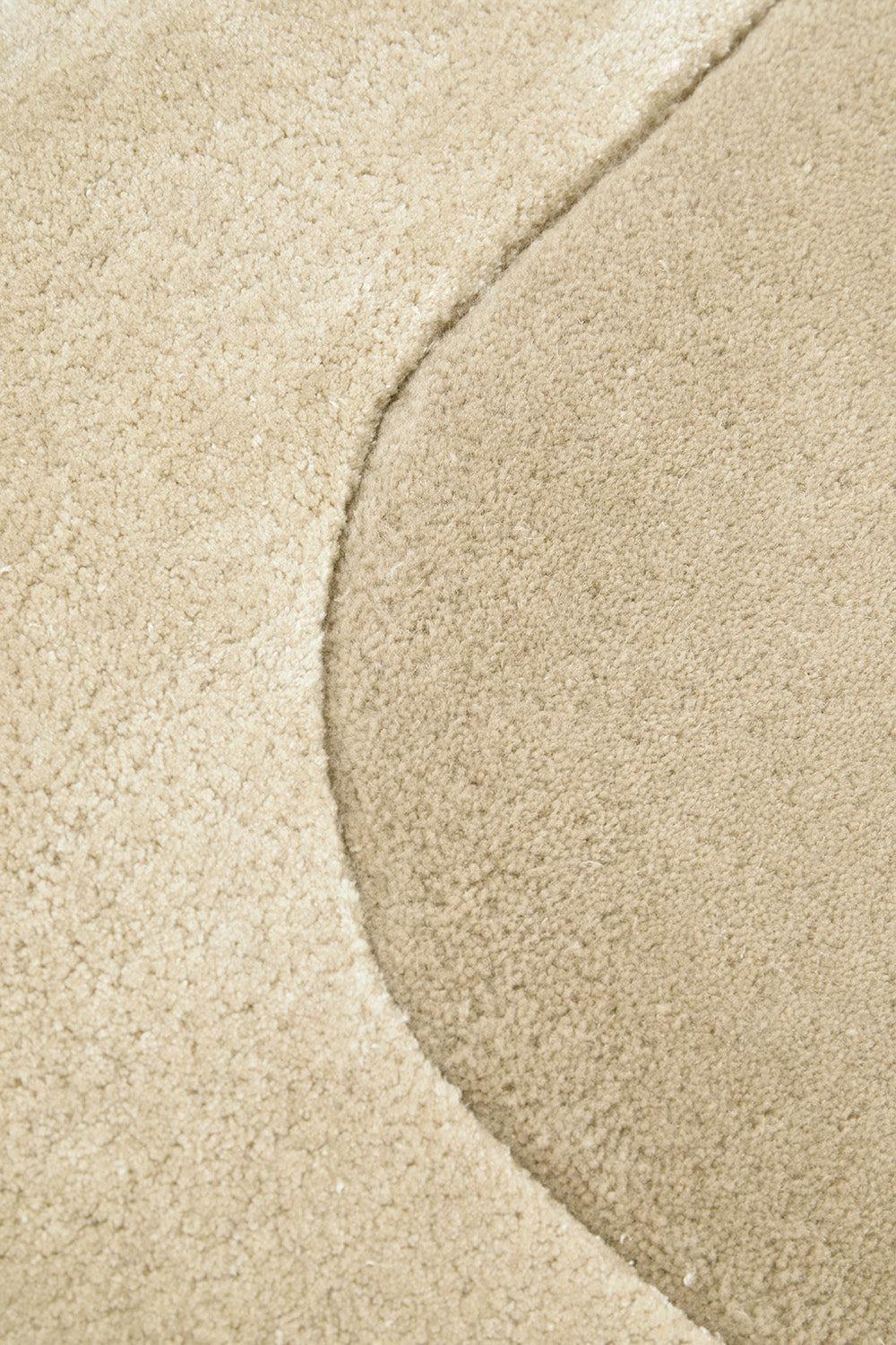 Hugo Husk Rug featuring curved beige-sand design on cream background, hand-tufted wool