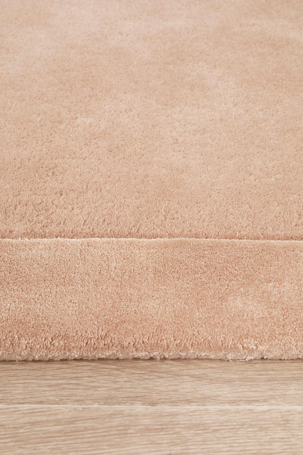 Hugo Nude Rug featuring solid colour design in nude beige on light wood background, machine-made polypropylene