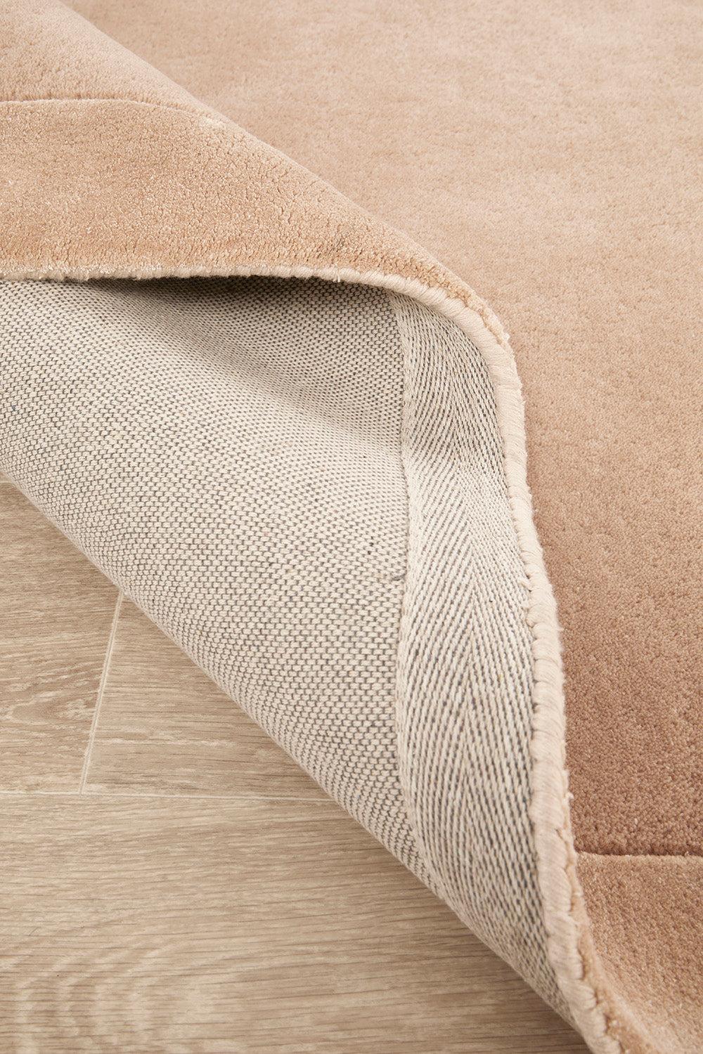Hugo Nude Rug featuring solid minimalist design in nude beige on light oak floor, machine-made wool