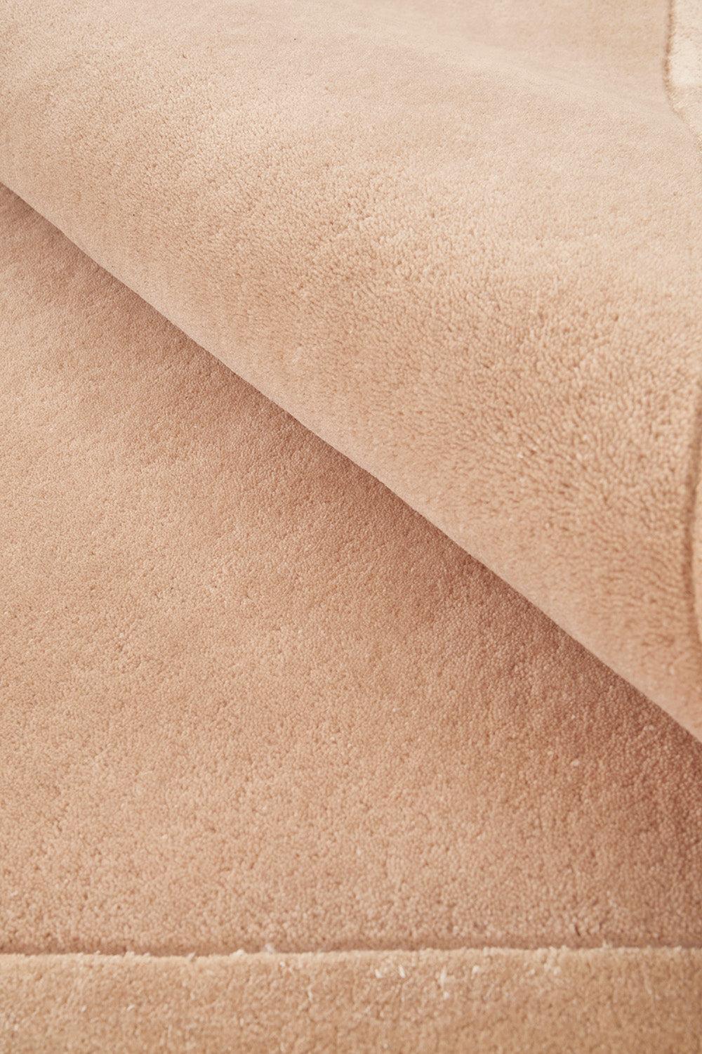 Hugo Nude Rug featuring solid textured weave in nude beige on cream background, hand-tufted wool