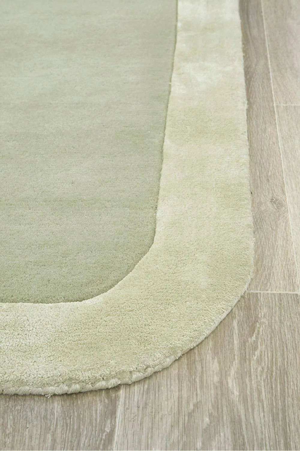 Hugo Sage Runner Rug featuring solid tonal shading in sage green and cream border on pale beige background, hand-tufted wool