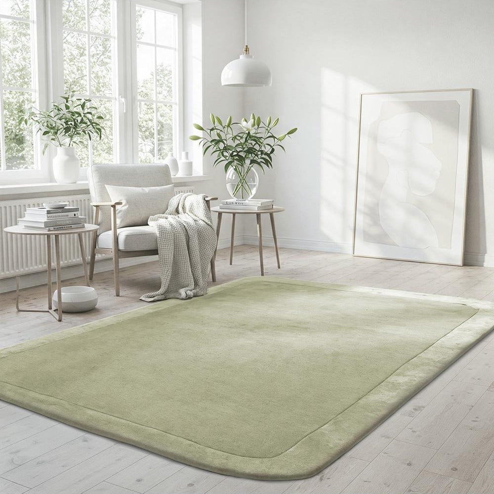 Light green rug in a room with white walls, a window, and a chair.