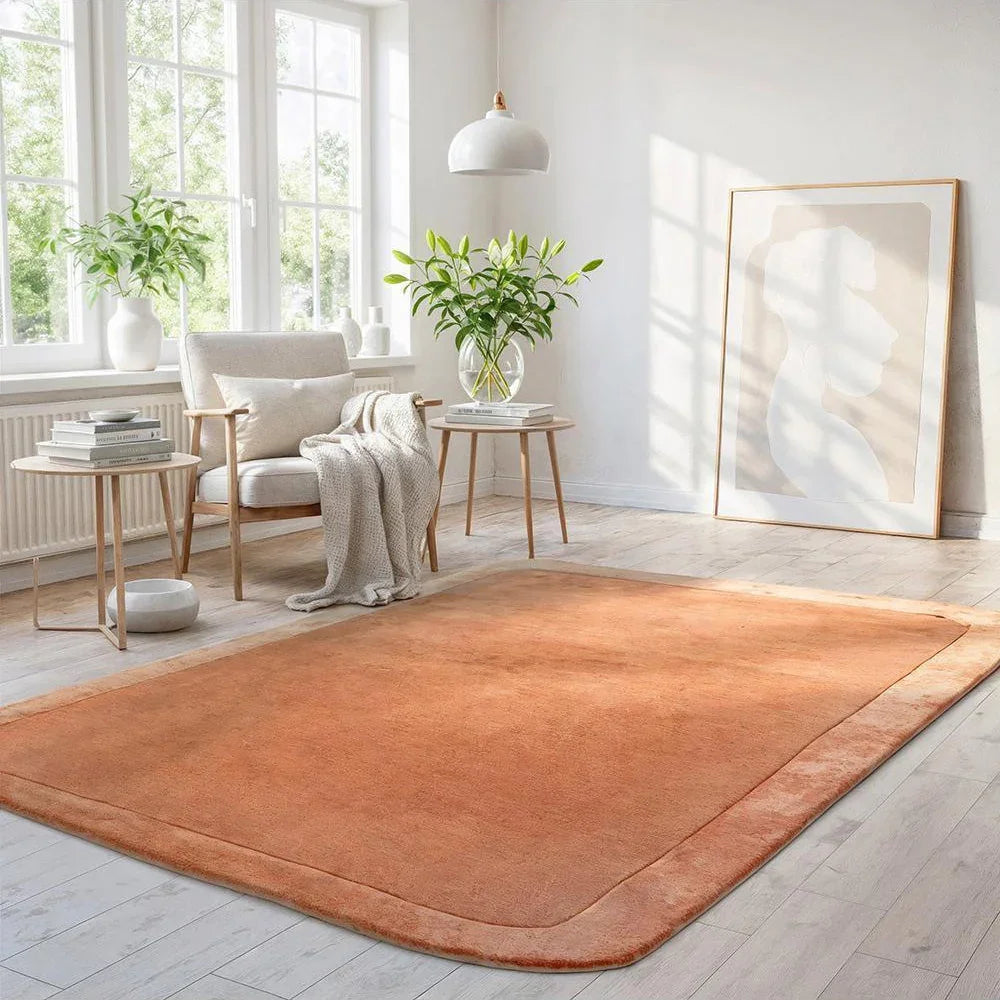 Hugo Spice Rug featuring solid spice orange with subtle apricot edge on light cream room floor, hand-tufted wool