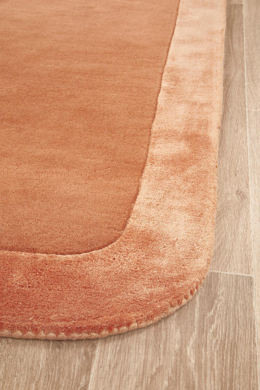 Hugo Spice Rug featuring plush terracotta field with peach border on warm cream, hand-tufted wool