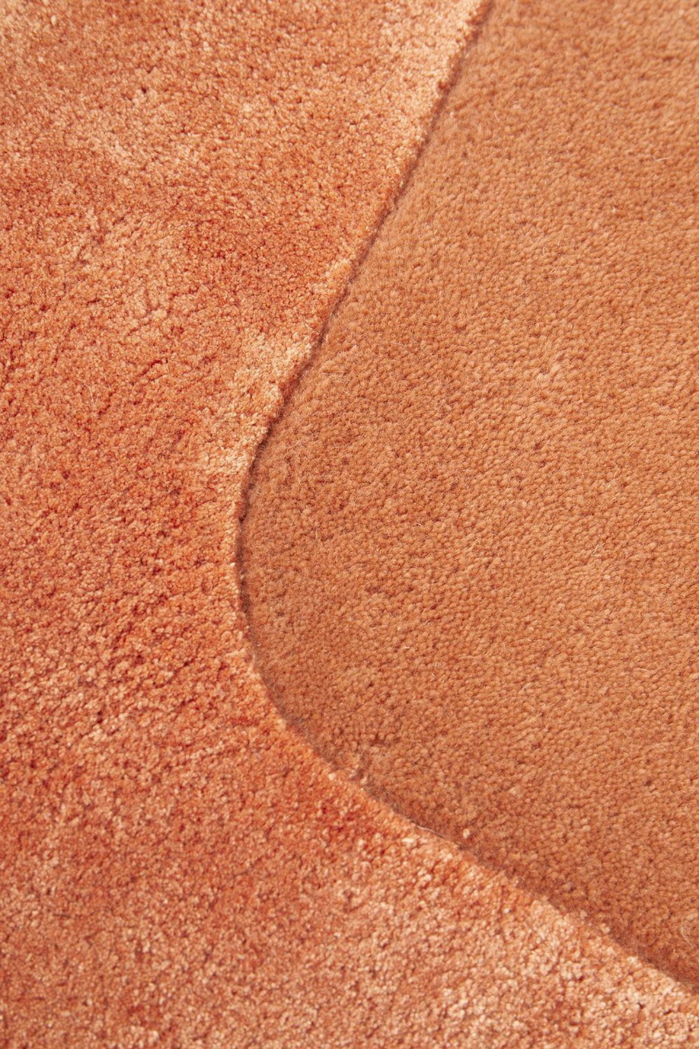 Hugo Spice Rug featuring warm textured pattern in terracotta, burnt orange and cinnamon on pale cream background, hand-tufted wool