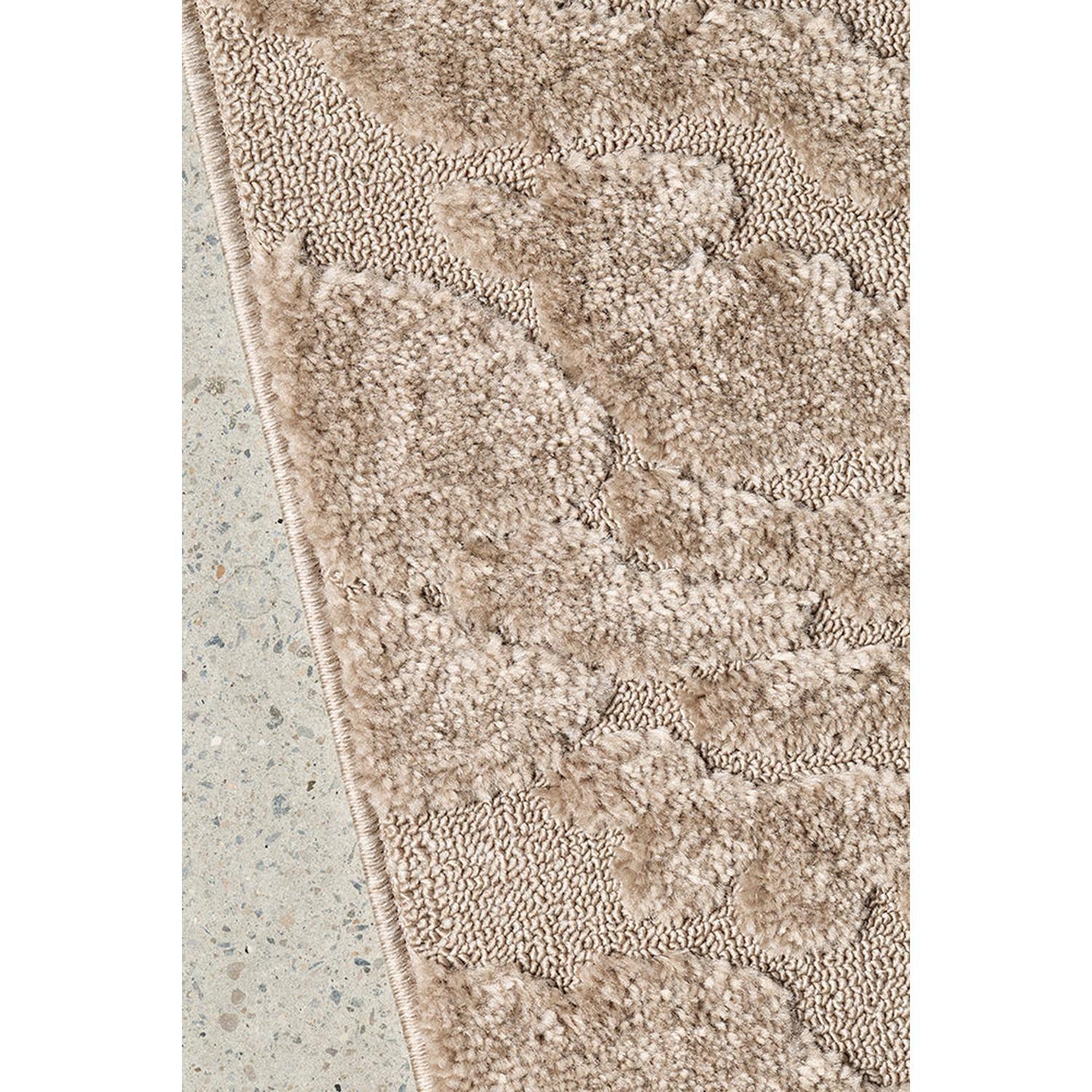 Close-up of a textured beige rug on a concrete floor