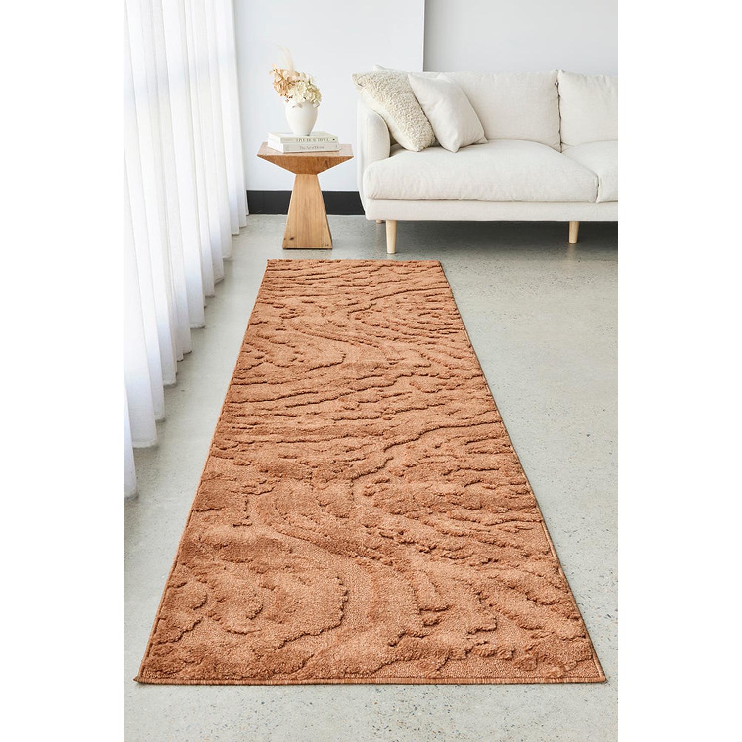 Brown textured runner rug on a light gray floor in a living room setting.