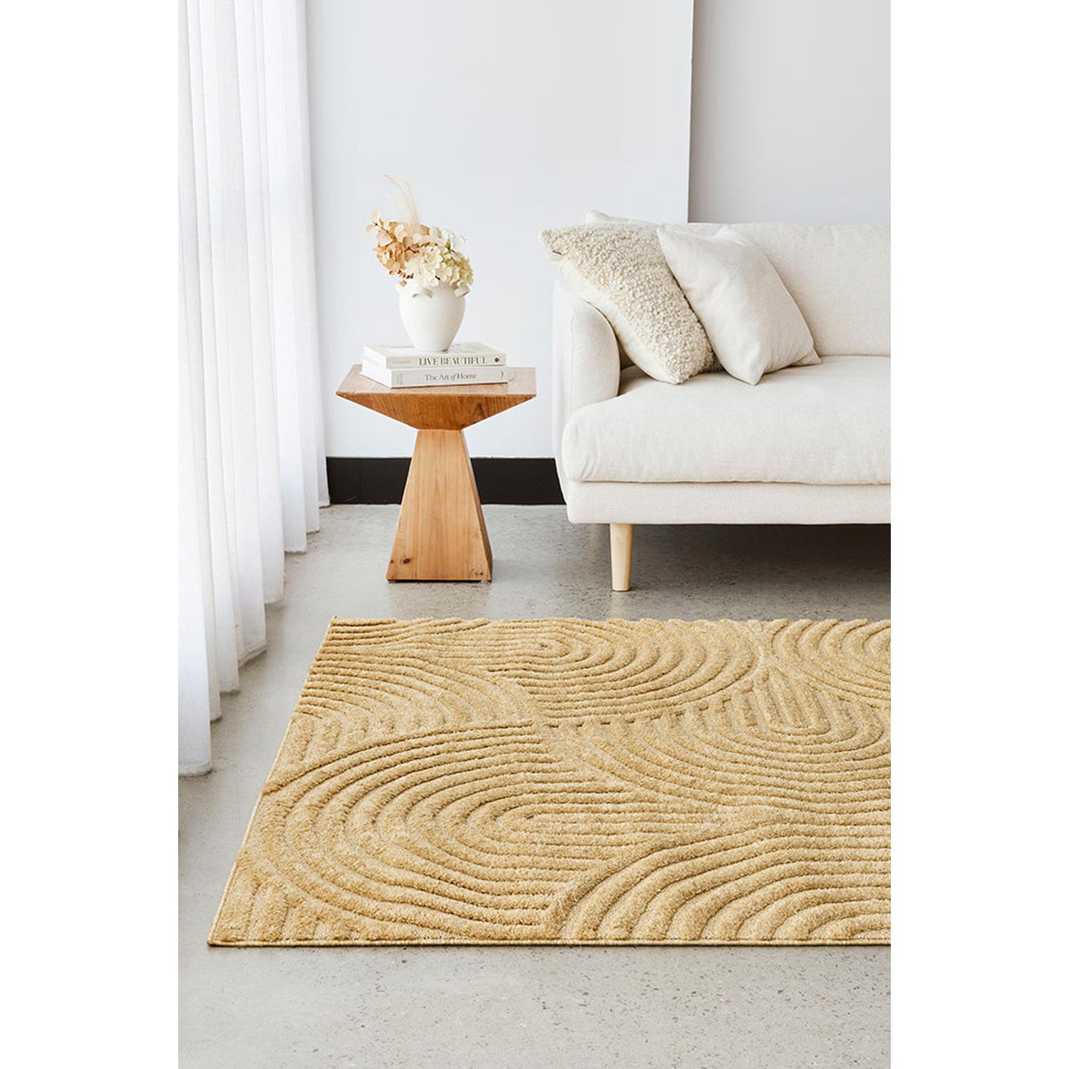 Beige textured rug in a living room with a white sofa and wooden side table.
