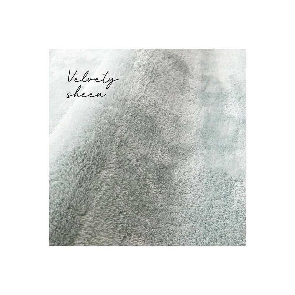 Jelly Bean Rug featuring velvety, plush gradient in powder blue, grey and ivory on a pale background, plush weave