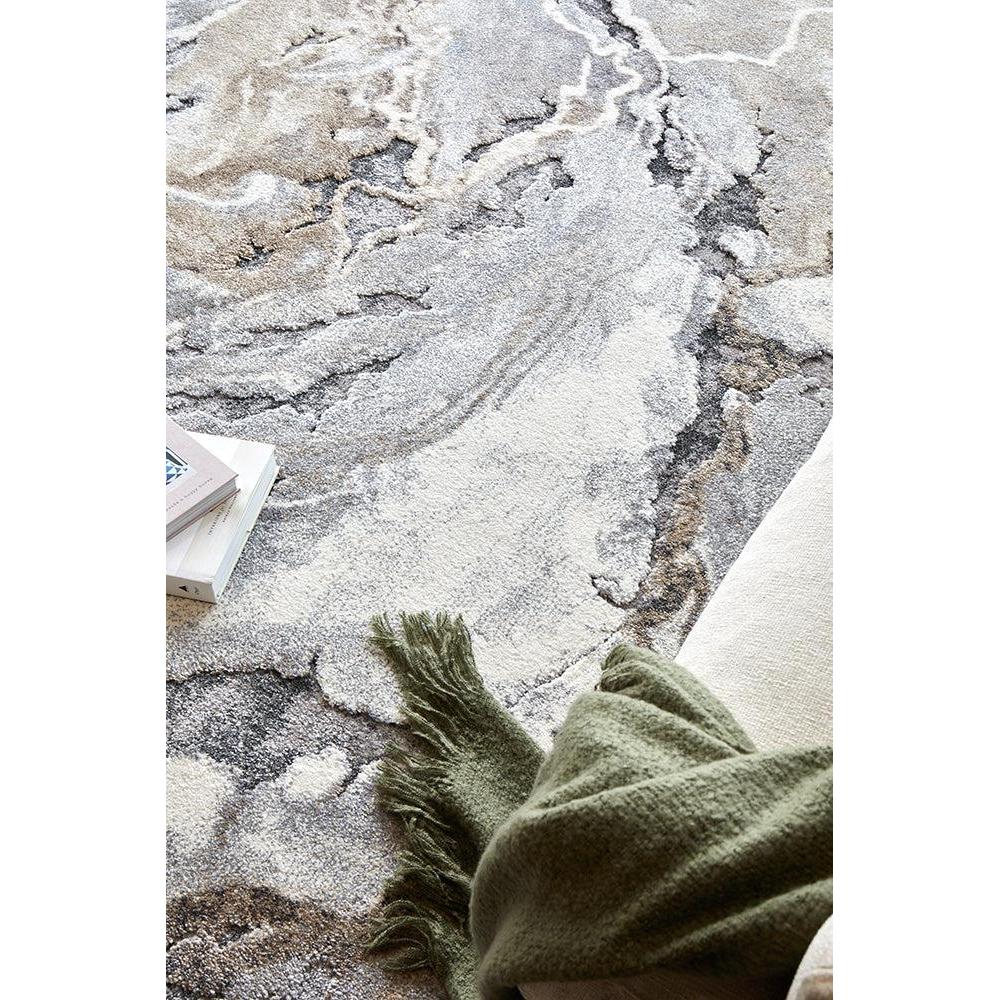 Textured gray and beige rug with a green throw blanket on a white background