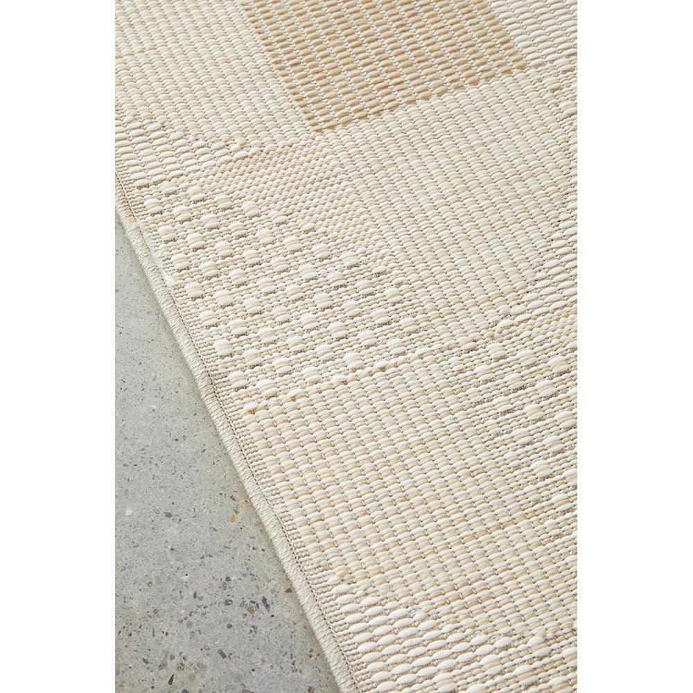 Patio Selin Natural Runner Indoor-Outdoor Rug featuring woven texture in cream and beige on grey concrete floor