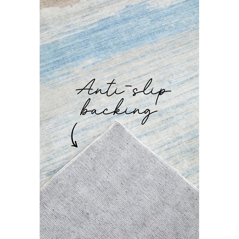 Revive Brody Tan Washable Rug featuring soft abstract striped pattern in light blue, cream and tan on pale beige background with anti-slip backing