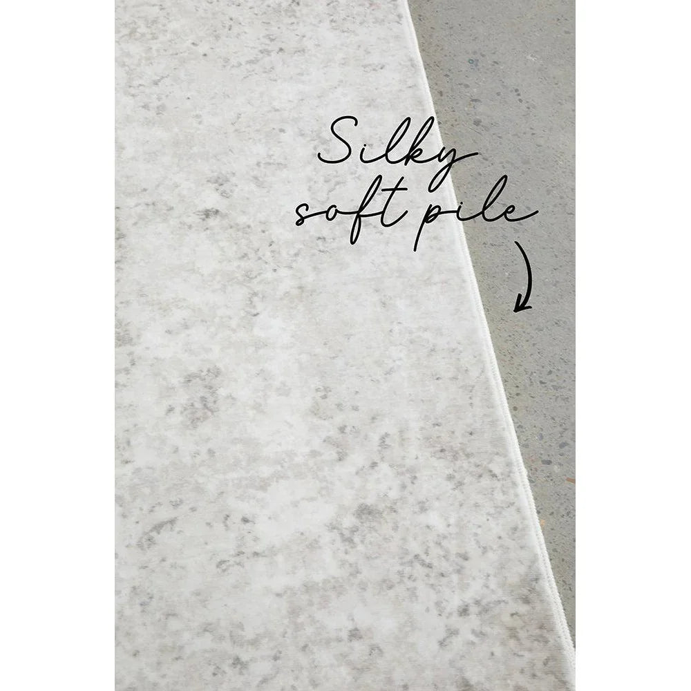 Revive Isla Marble Washable Rug featuring marble pattern in cream, ivory and light greys on pale grey background, machine-woven synthetic blend