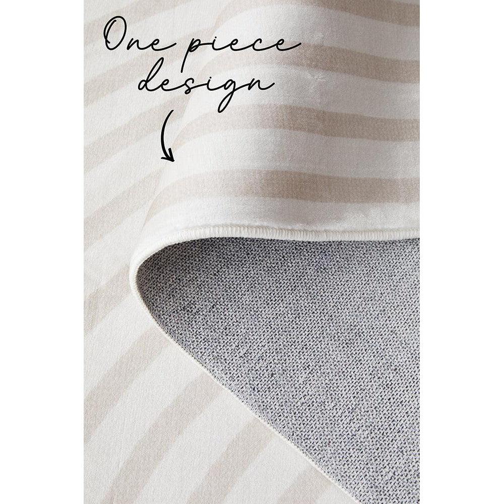 Revive Jett Natural Washable Rug featuring beige-ivory striped pattern on cream background, folded to reveal grey underside, washable rug
