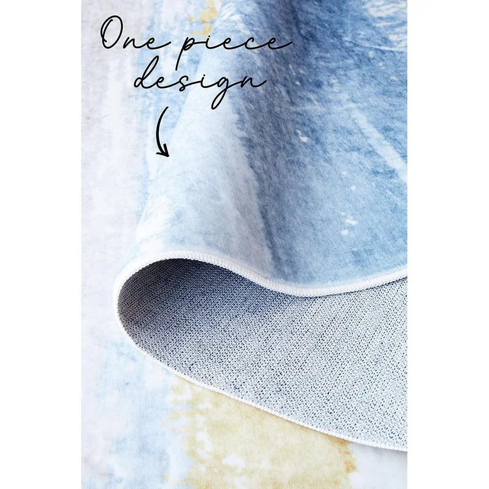 Revive Kyle Blue Washable Rug featuring tie-dye gradient in sky blue, navy blue and white on pale background, power-loomed polyester
