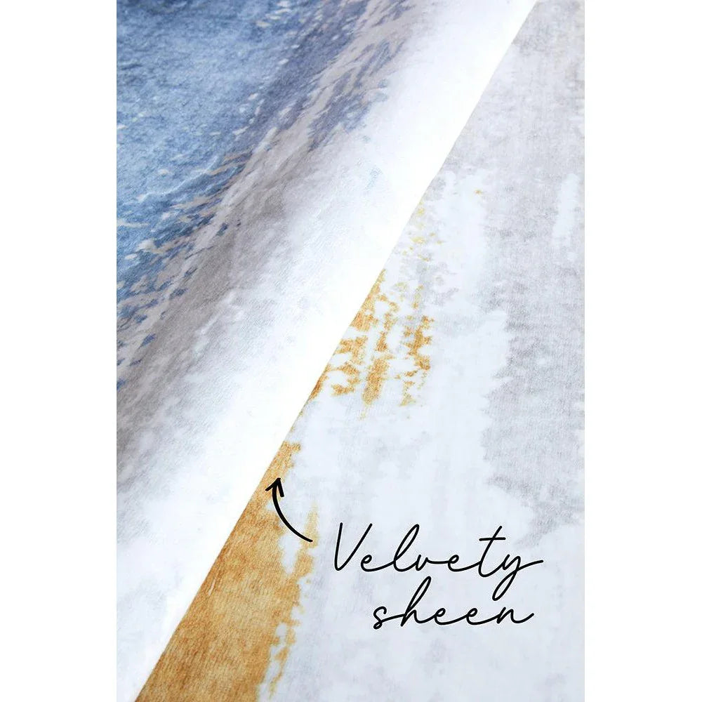 Revive Kyle Blue Washable Rug featuring abstract velvet-sheen gradient in blue, white and gold on light grey background, machine-woven blend