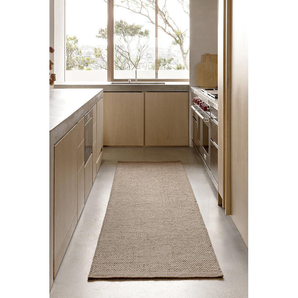 Steph And Gian Bark Walnut Rug featuring textured weave in walnut-brown, beige and cream on light grey floor, handwoven jute