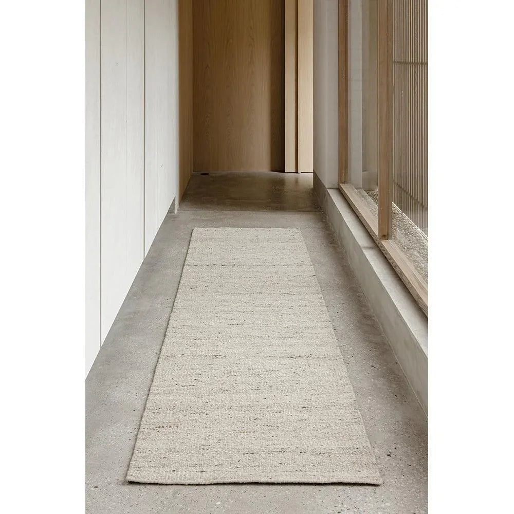 Steph And Gian Elm Pepper Runner Rug featuring textured weave in cream, beige on grey concrete floor, hand-woven jute