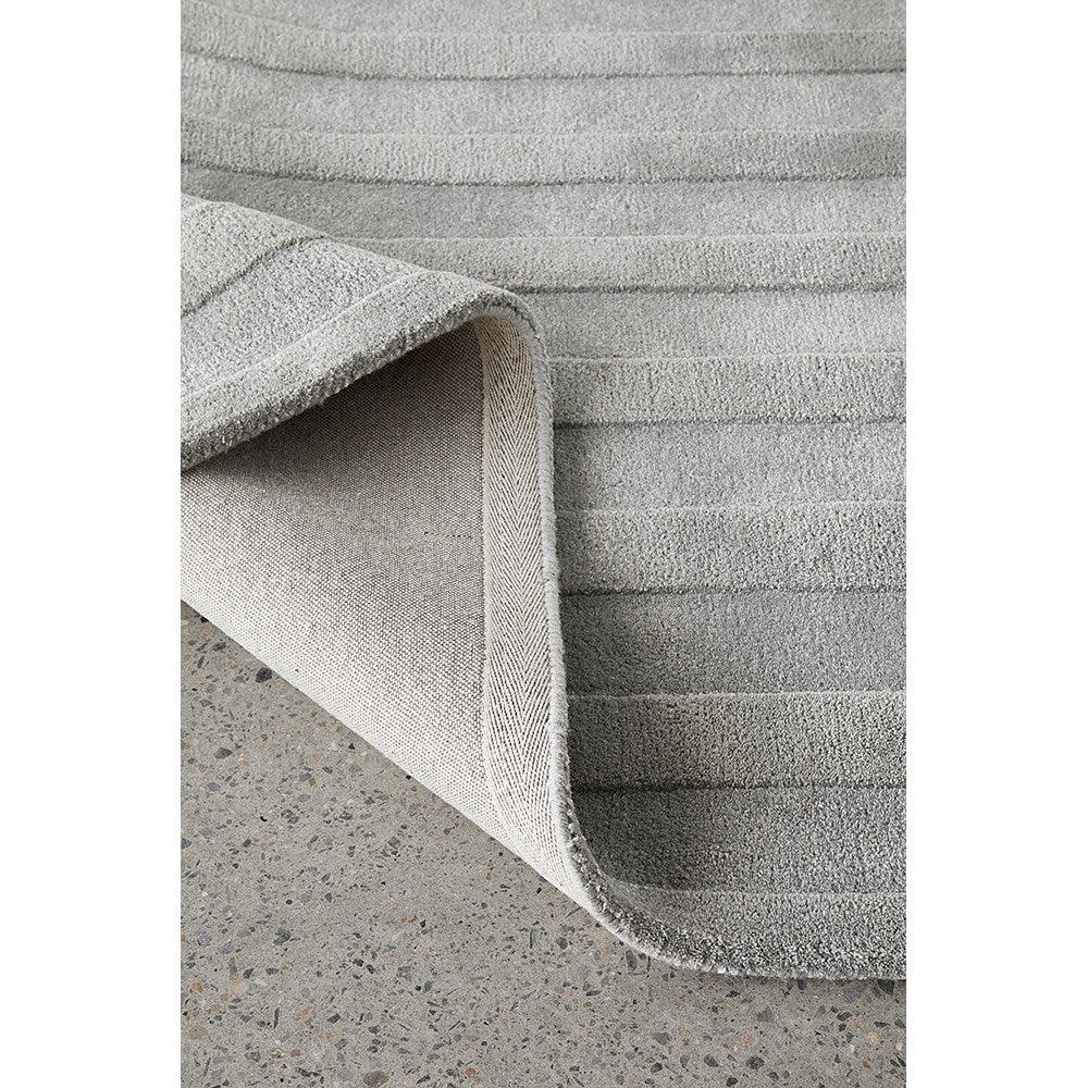 Summmit Trail Grey rug featuring striped texture in light grey and charcoal on pale concrete background, woven construction