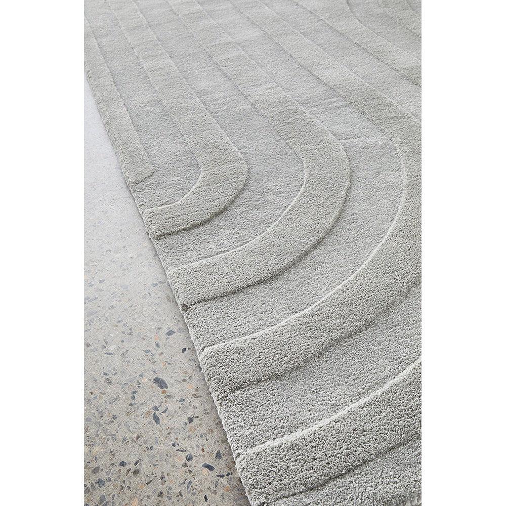 Summit Trail Grey rug featuring curved arc pattern in light grey and charcoal on pale grey background, machine-made pile