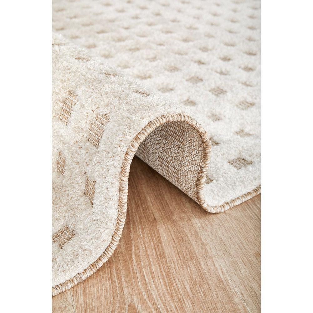 Villa Raine Natural Rug featuring subtle dotted pattern in cream, ivory and beige on warm oak background, machine-woven wool