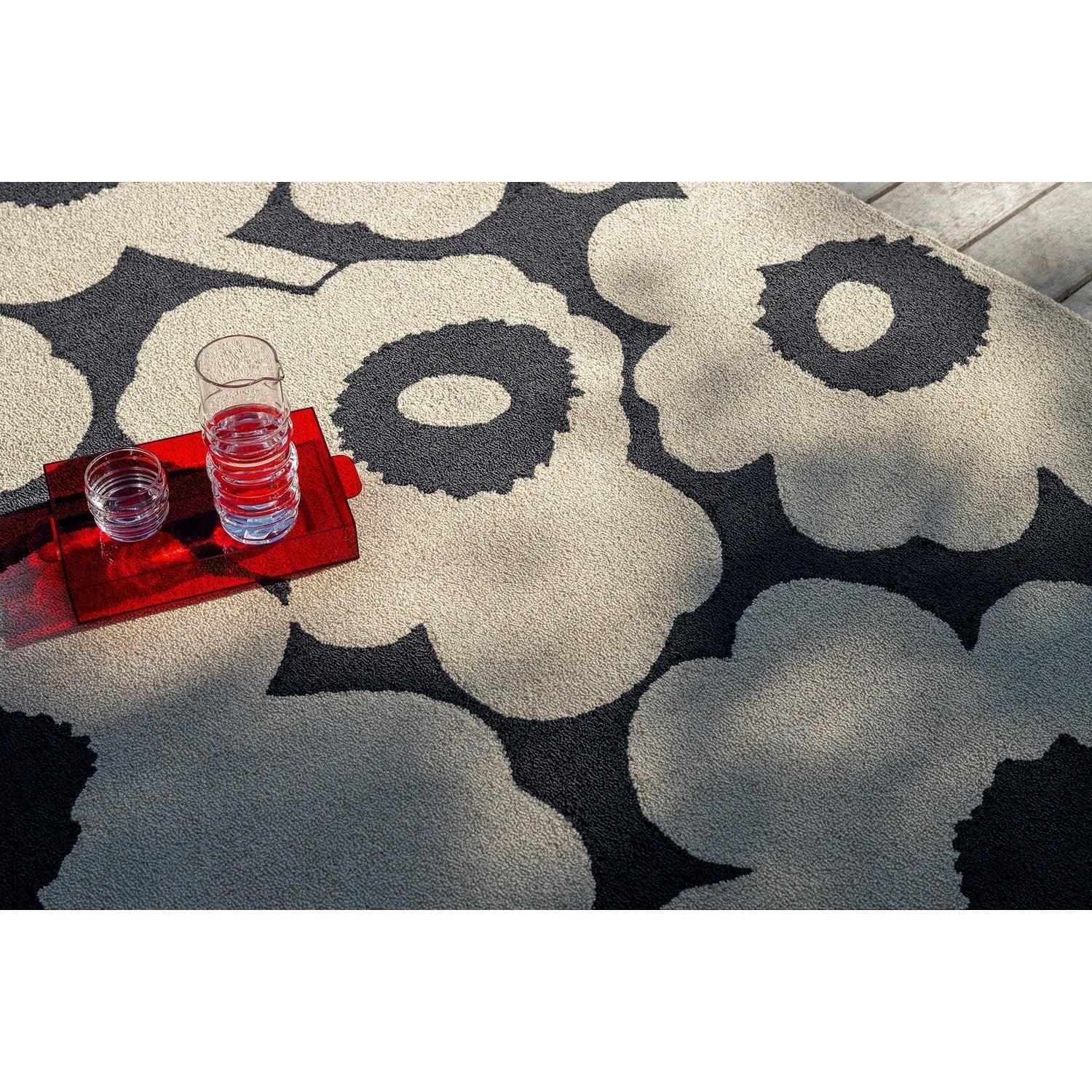 ICONIC RUGS Marimekko Unikko charcoal and ivory outdoor rug with oversized poppy design. Handtufted recycled PET.