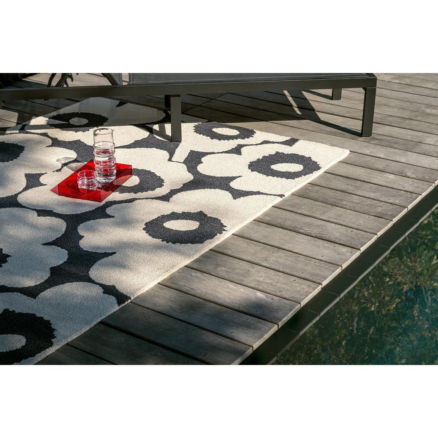 ICONIC RUGS Marimekko Unikko charcoal and white outdoor rug with oversized poppy design. Handtufted recycled PET.