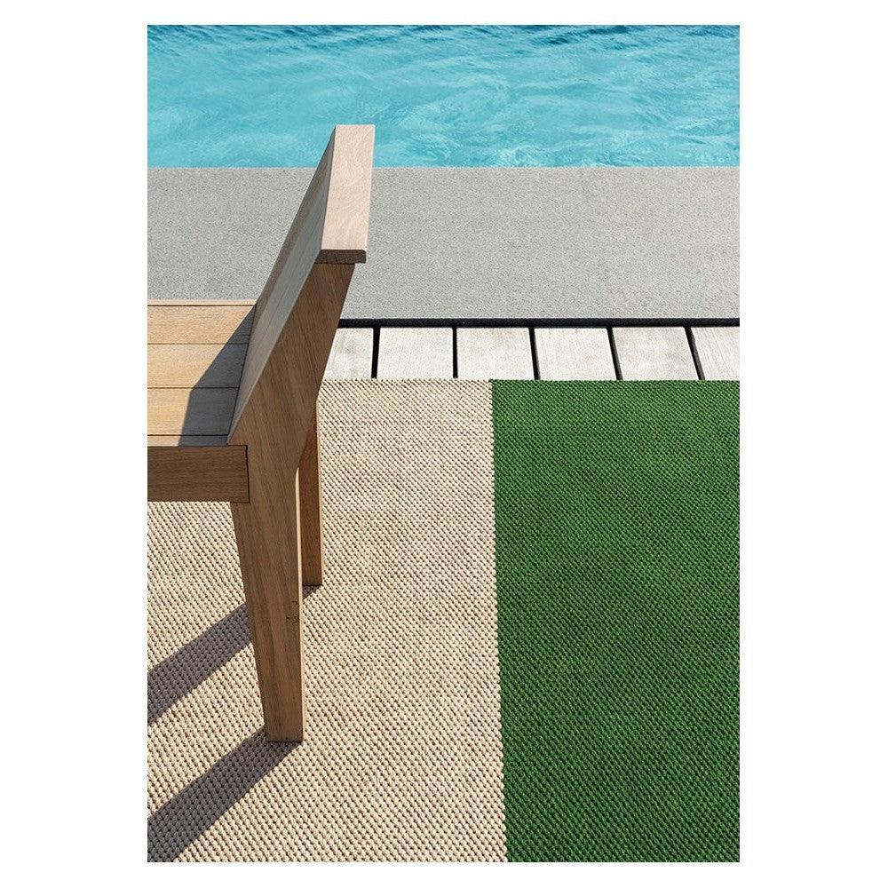 Brink & Campman Deck Spring Green outdoor rug featuring color-block geometric pattern in spring green and beige on light gray pool deck