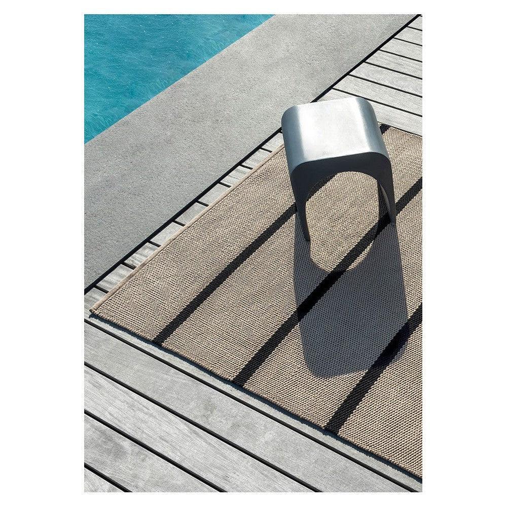 Brink & Campman Deck Charcoal Black Outdoor Rug featuring plain woven texture in beige on grey deck, power-loomed polypropylene