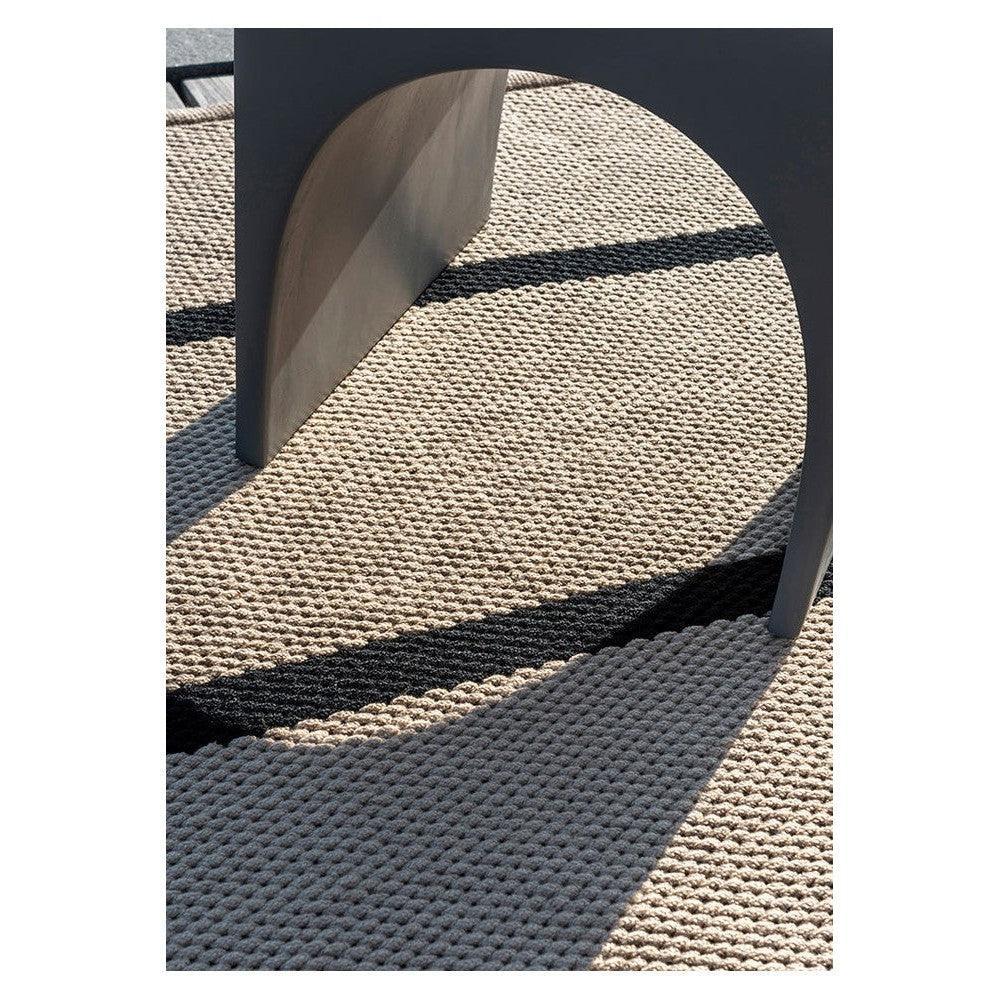 Brink & Campman Deck Charcoal Black outdoor rug featuring textured weave in charcoal tones with furniture shadow