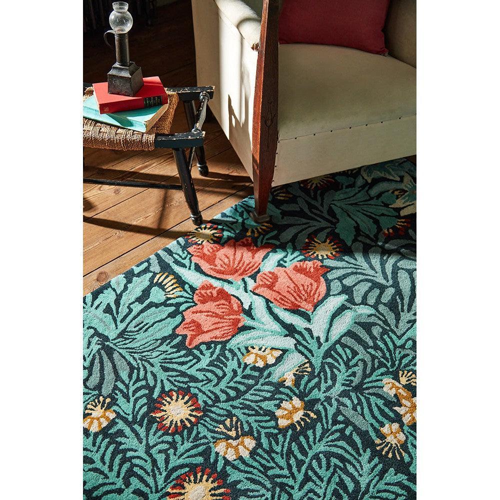 Morris & Co Bower Indigo Rug featuring botanical floral pattern in coral, teal and cream on teal background, hand-tufted wool