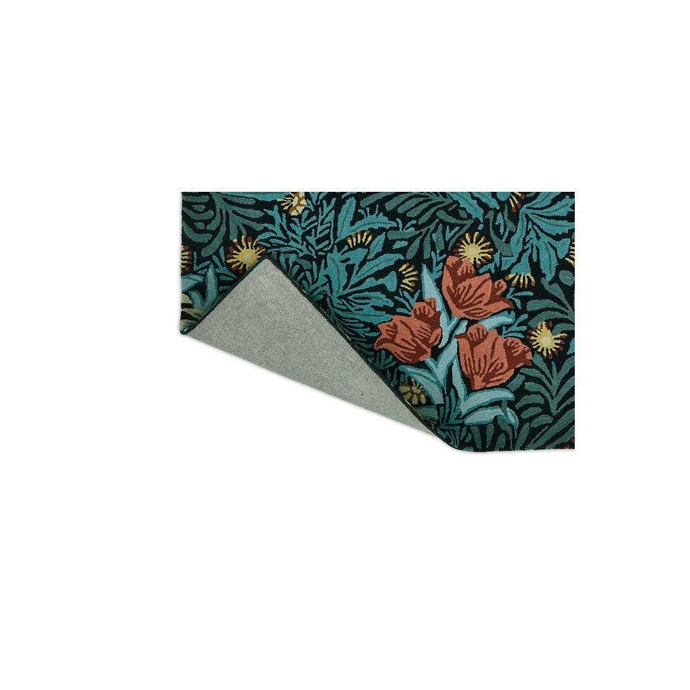 Morris & Co Bower Indigo rug featuring botanical floral pattern in teal, coral and ochre on deep indigo, hand-tufted wool
