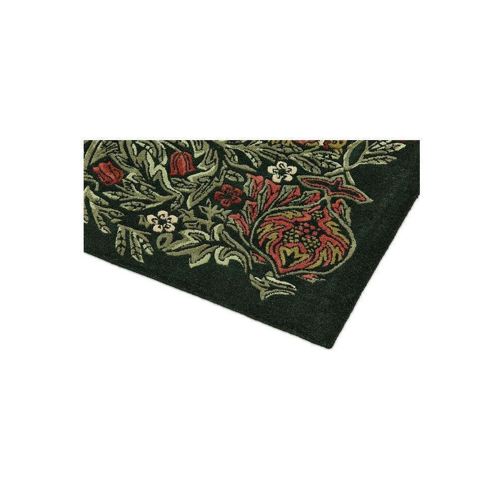 Morris & Co Bird Tump Green Designer Rug featuring botanical floral pattern in dark green, emerald and red on deep green background, hand-tufted wool