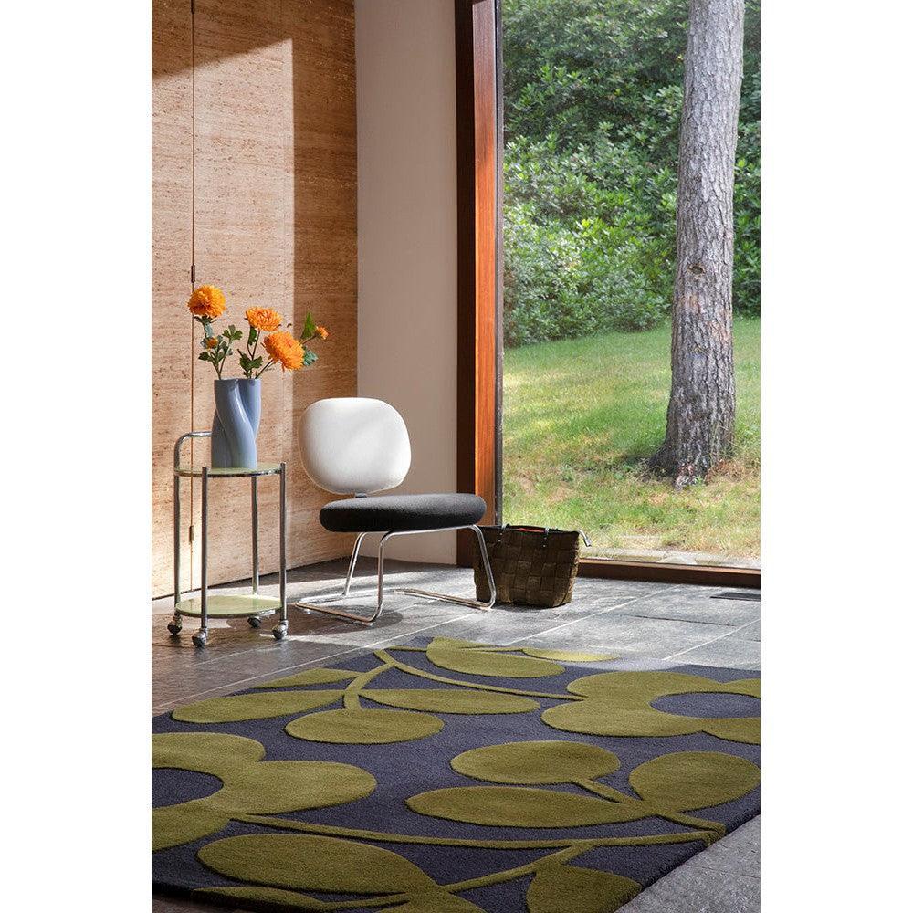 Orla Kiely Sprig Stem Marine Designer Rug featuring abstract botanical pattern in olive green, lime, and charcoal on navy background, hand-tufted wool