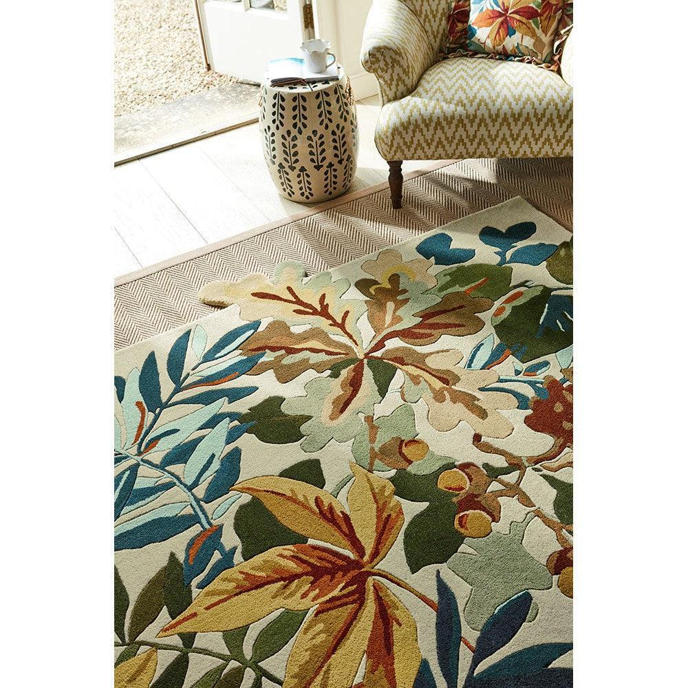 Sanderson Robin's Wood Russet Brown Rug featuring botanical leaf pattern in russet, sage, teal on ivory background, hand-tufted wool