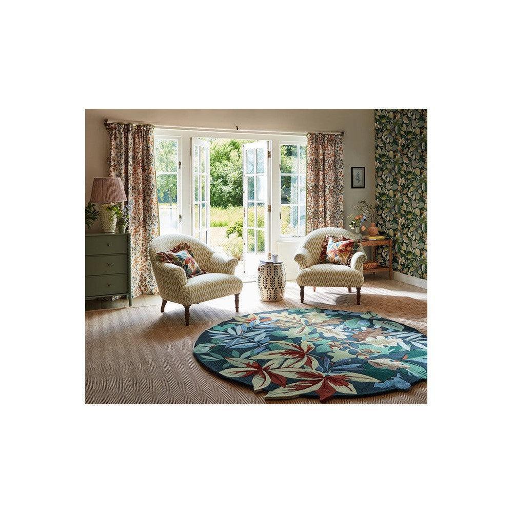 Sanderson Robin's Wood Round Rug featuring tropical leaf pattern in forest green, teal and cream on beige background, hand-tufted wool