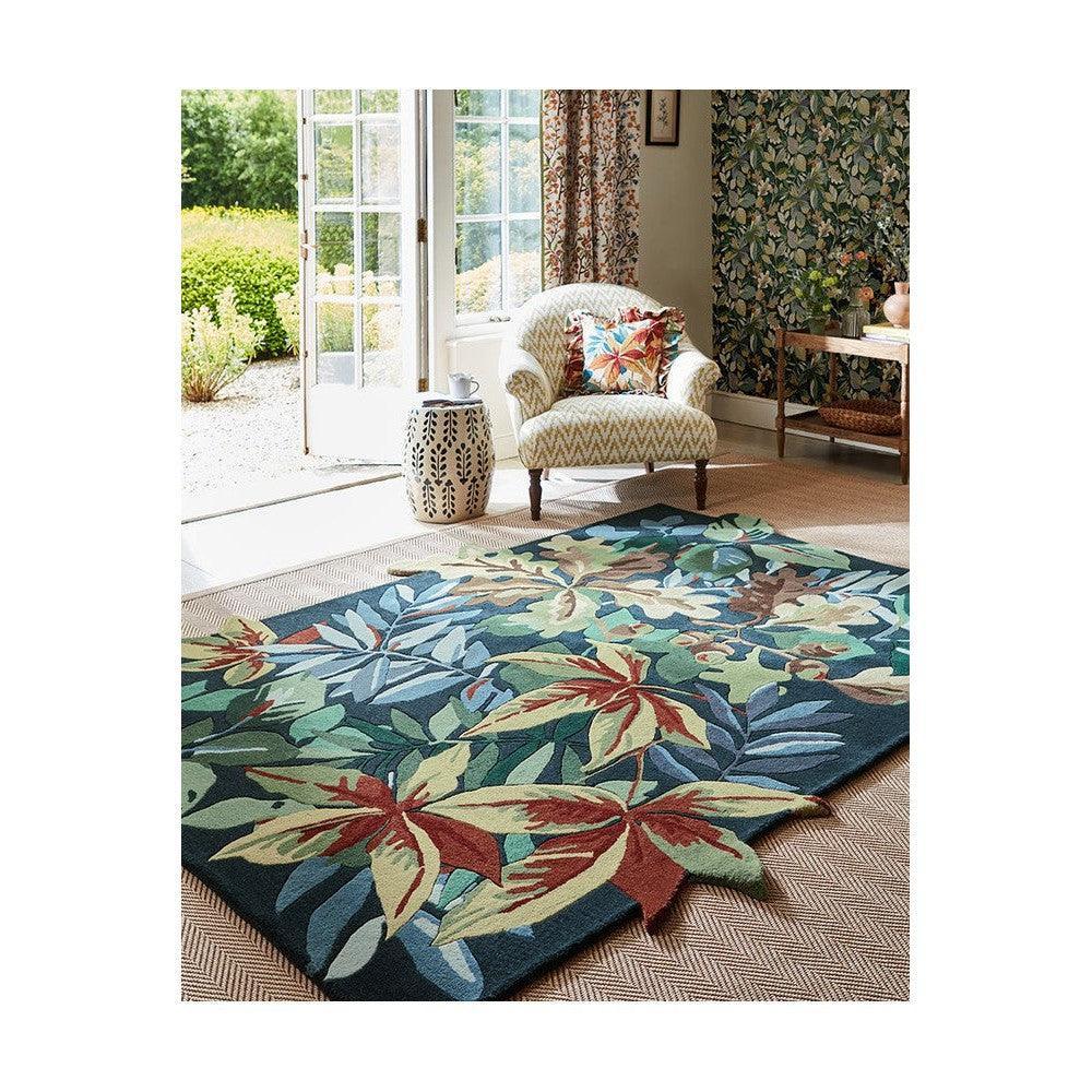 Sanderson Robin's Wood forest green rug featuring tropical leaf pattern in emerald, teal, cream on dark background, machine-woven wool blend