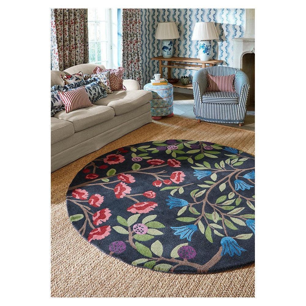 Sanderson Foraging Indigo Round Designer Rug featuring bold floral pattern in navy, pink, green and blue on navy background, hand-tufted wool