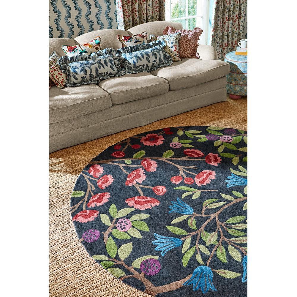 Sanderson Foraging Indigo Round Rug featuring botanical floral pattern in pink, red, green and blue on navy background, hand-tufted wool