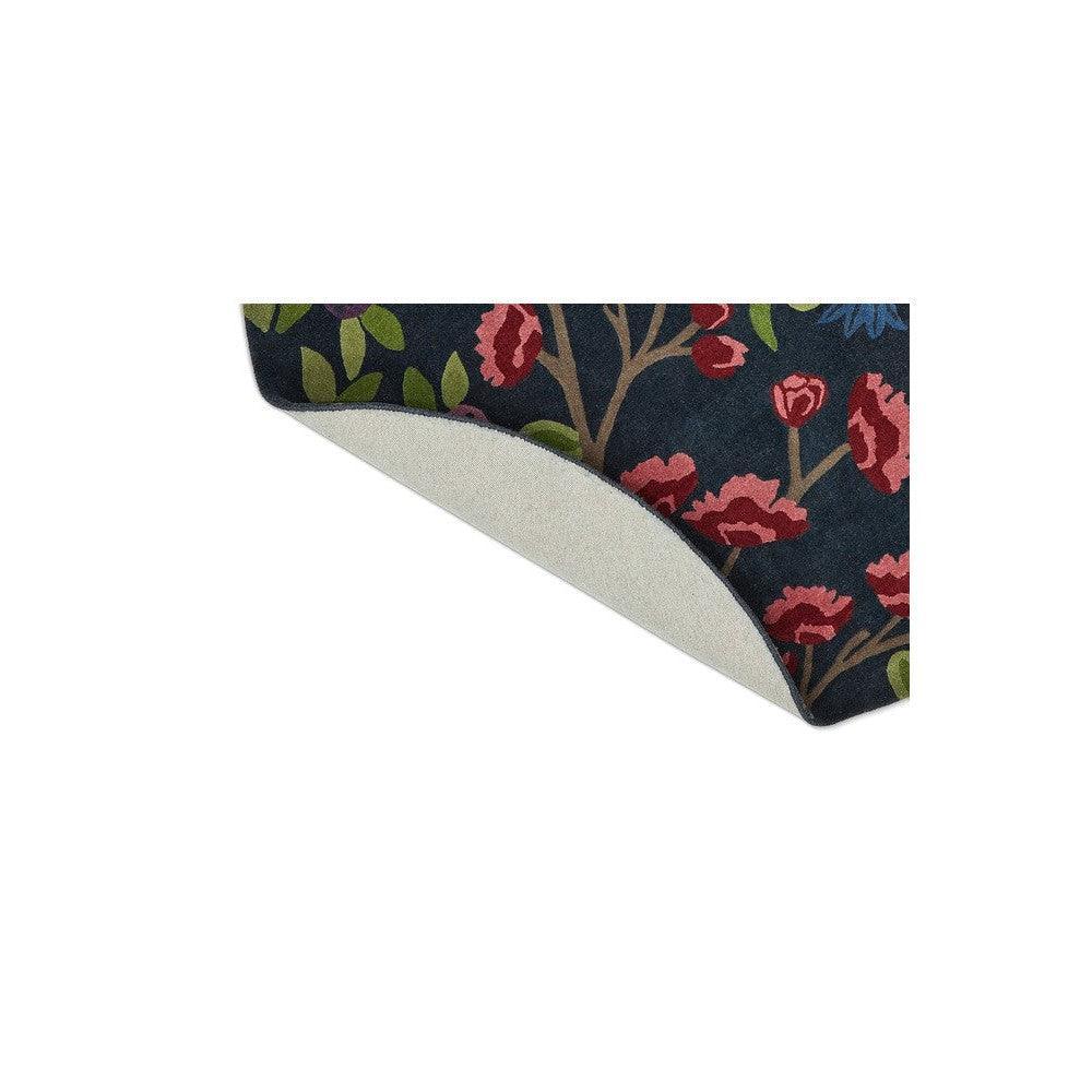 Sanderson Foraging Indigo Round Rug featuring botanical floral pattern in navy, red, pink and green on dark background, hand-tufted wool