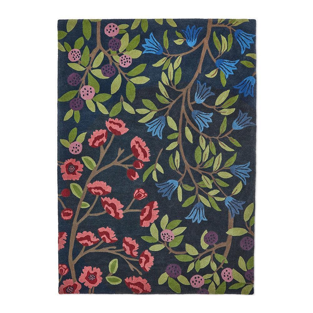 Sanderson Foraging Indigo Rug featuring botanical floral pattern in navy, cobalt blue, greens, pink and purple on indigo background, hand-tufted wool